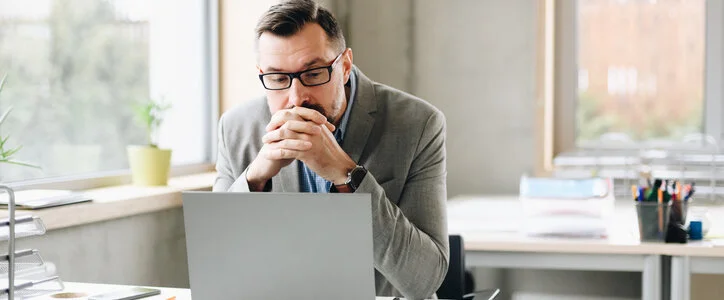 middle aged man looking at laptop