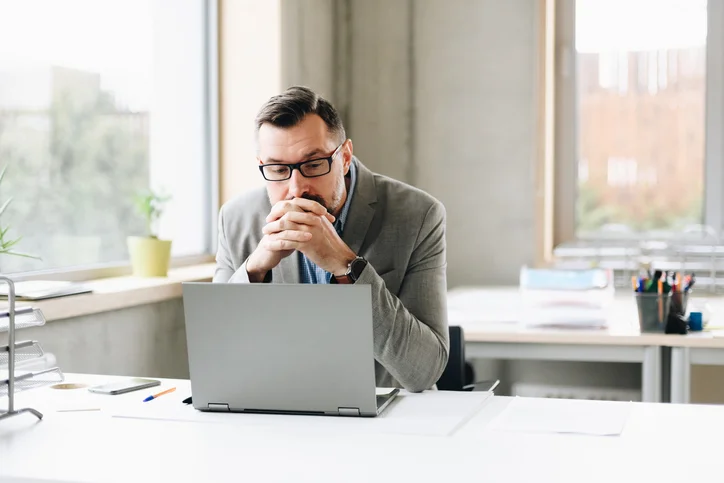 middle aged man looking at laptop